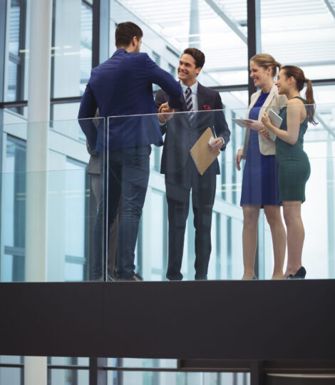 Business executives shaking hands in the corridor at office